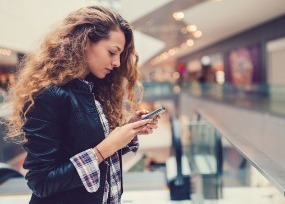 Woman using phone in mall