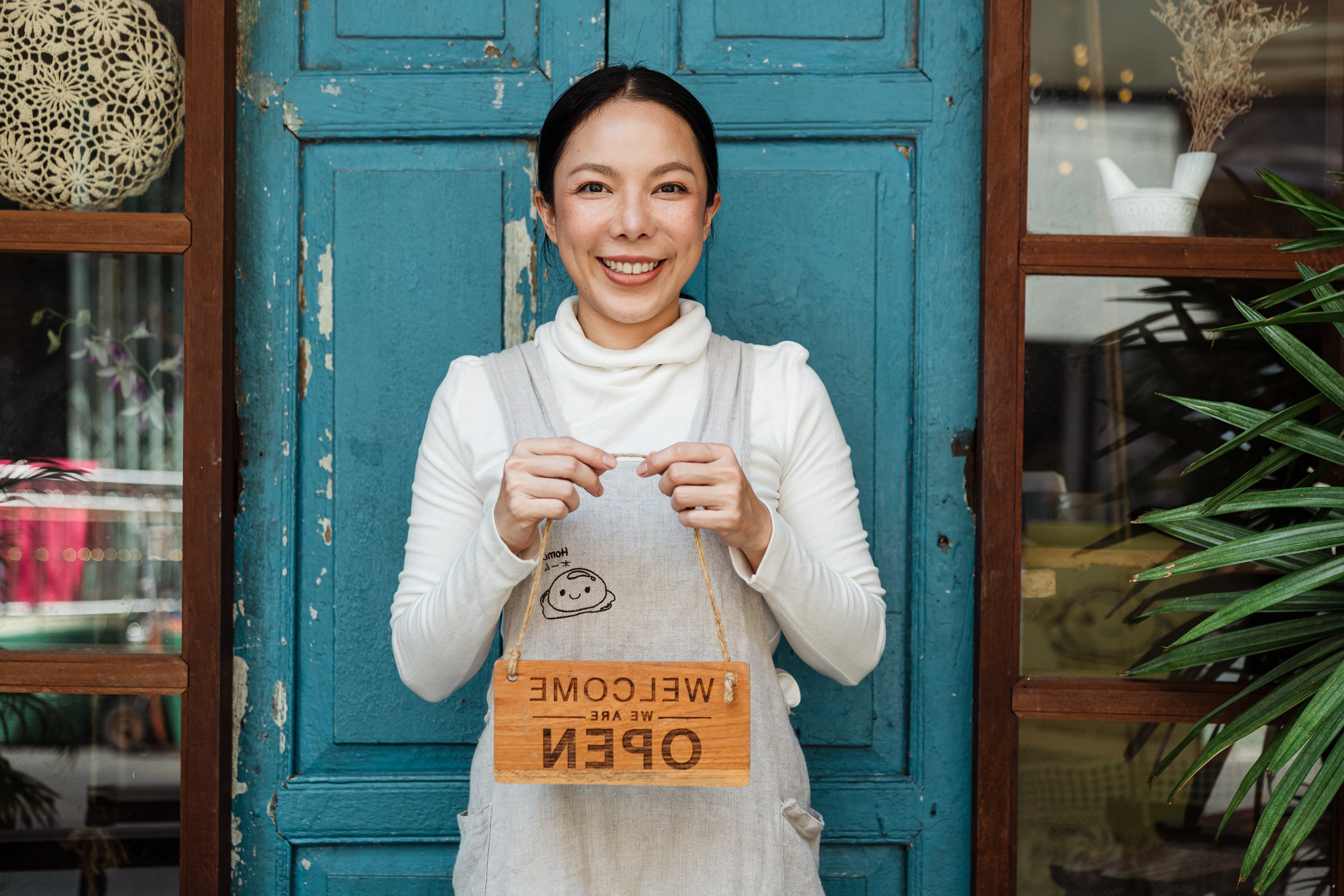 Woman holding open sign