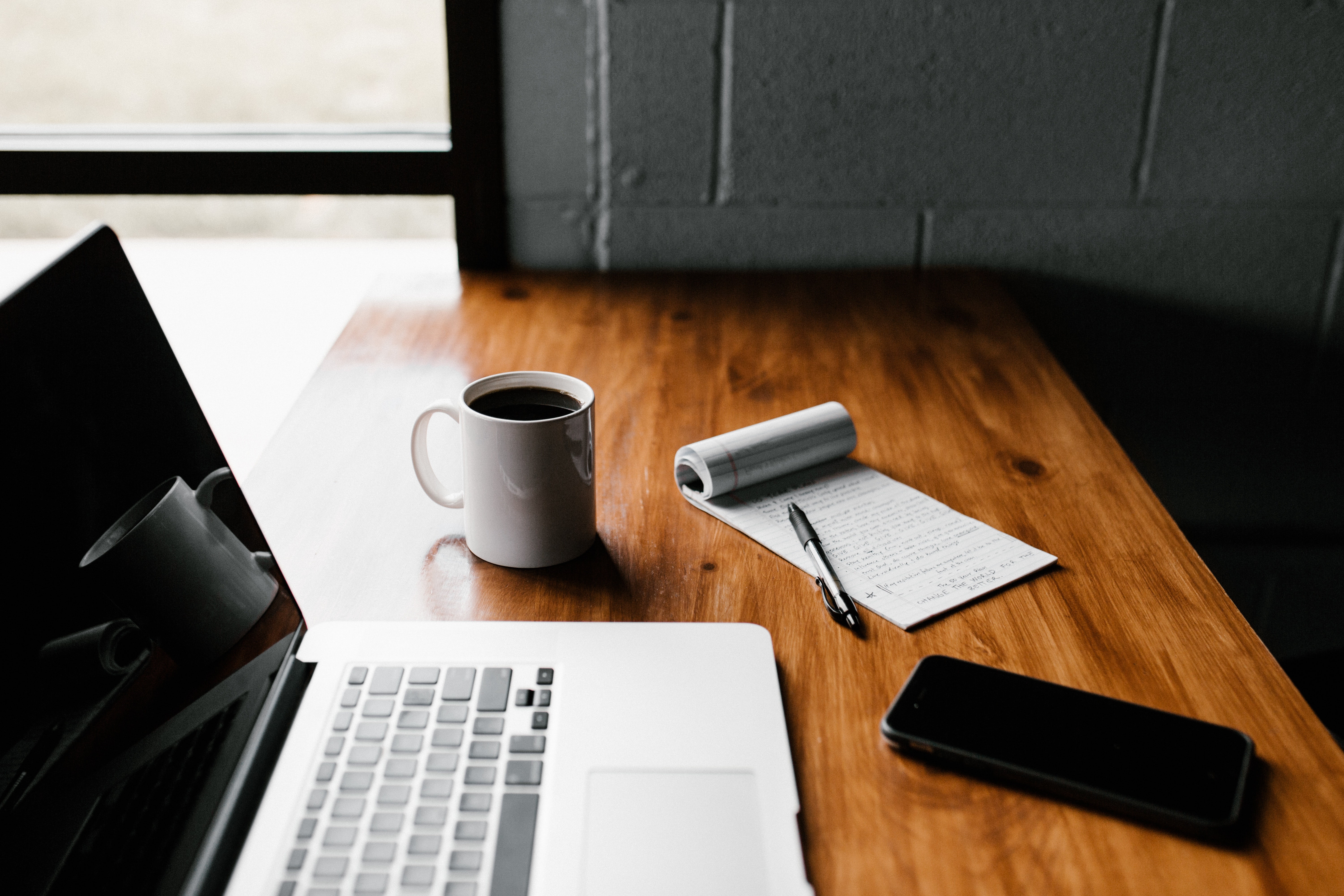 Image of laptop on desk with coffee mug.