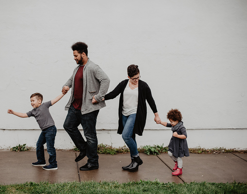 Young family walking on sidewalk