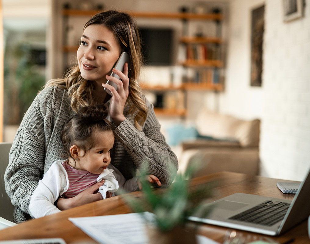 Mother and daughter using laptop in living room