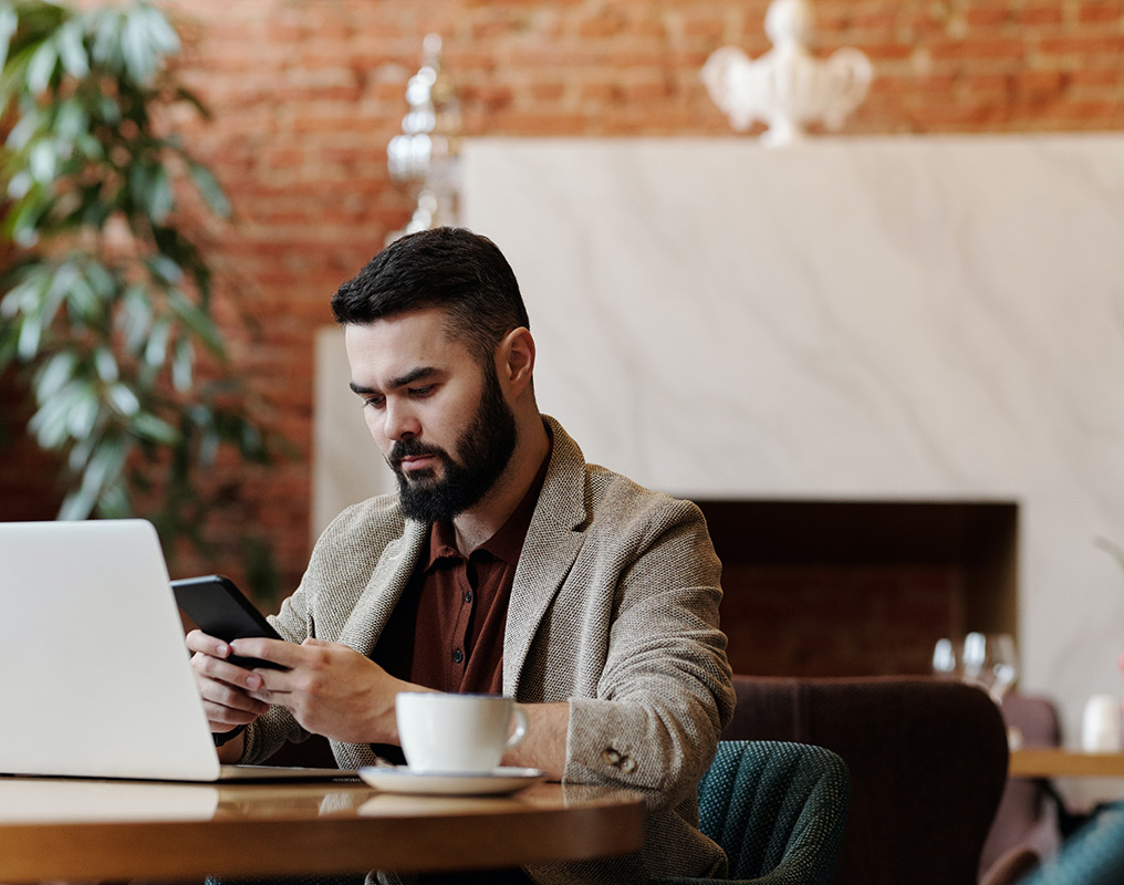 Man using laptop and phone