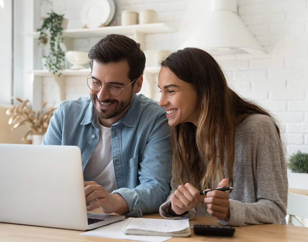 Couple using laptop in kitchen