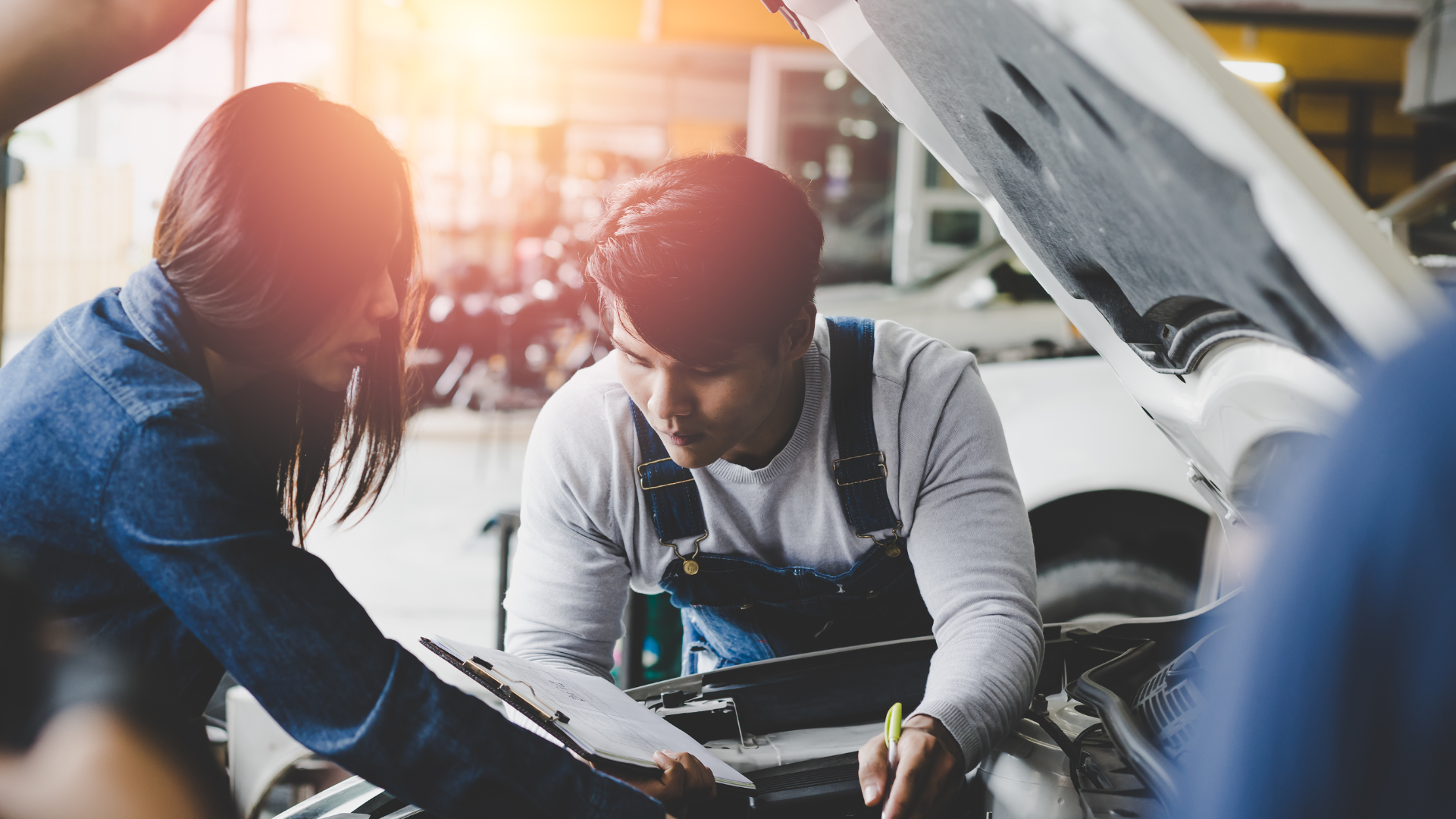 Man helping woman fix her car. 