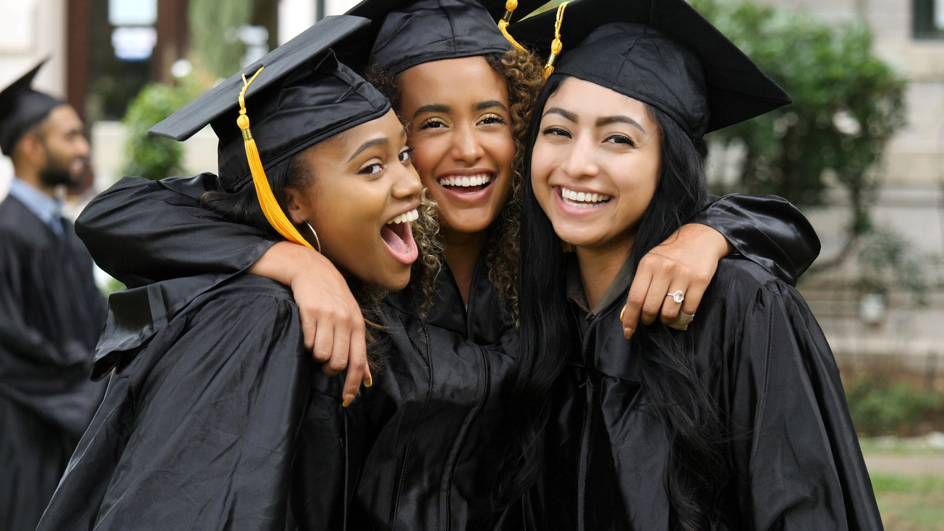 Three girls in college graduation outfits.