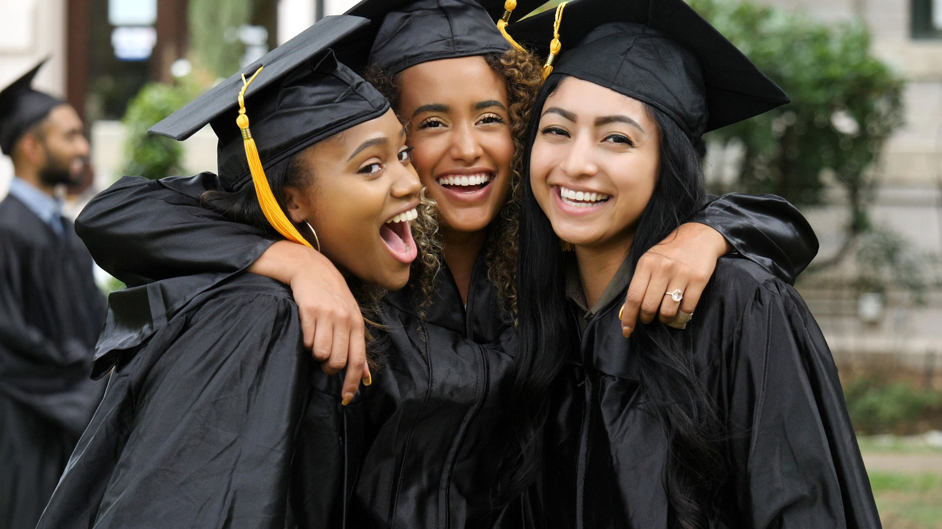 Three girls in college graduation outfits. 