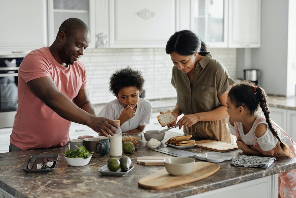 Family making meal in kitchen.