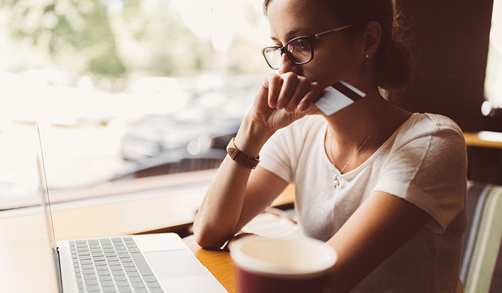 Woman using debit card with computer