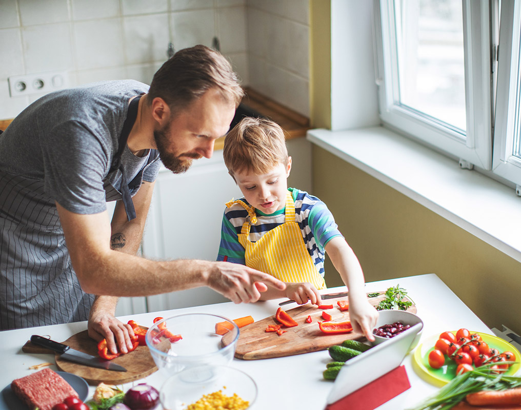 Father and son cooking in kitchen