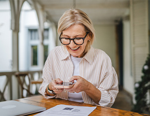 Mature woman taking a picture of papers on her phone