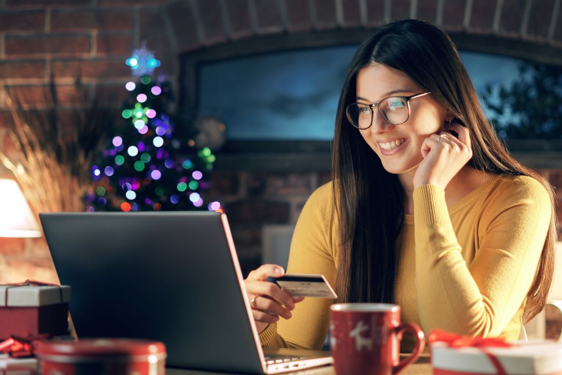Woman looking at card in front of laptop during holidays