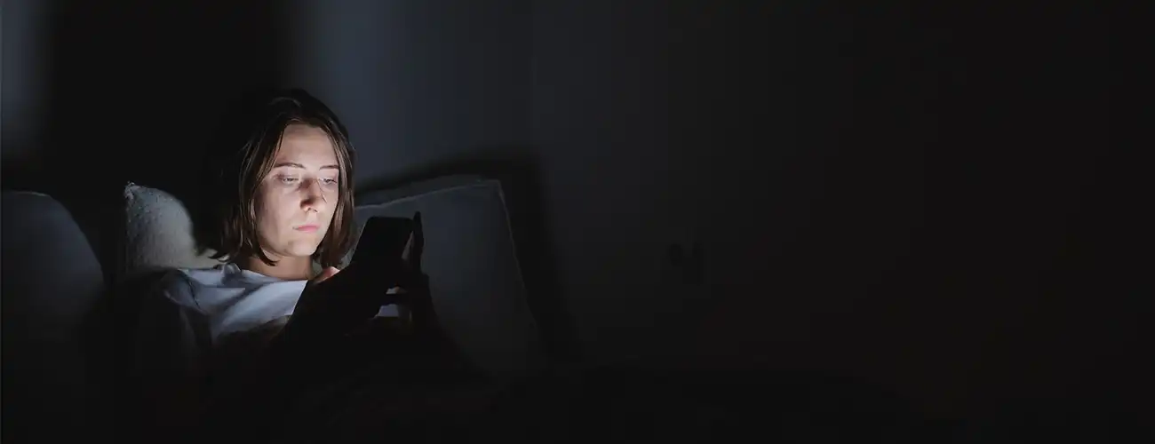 Girl looking at phone in dark