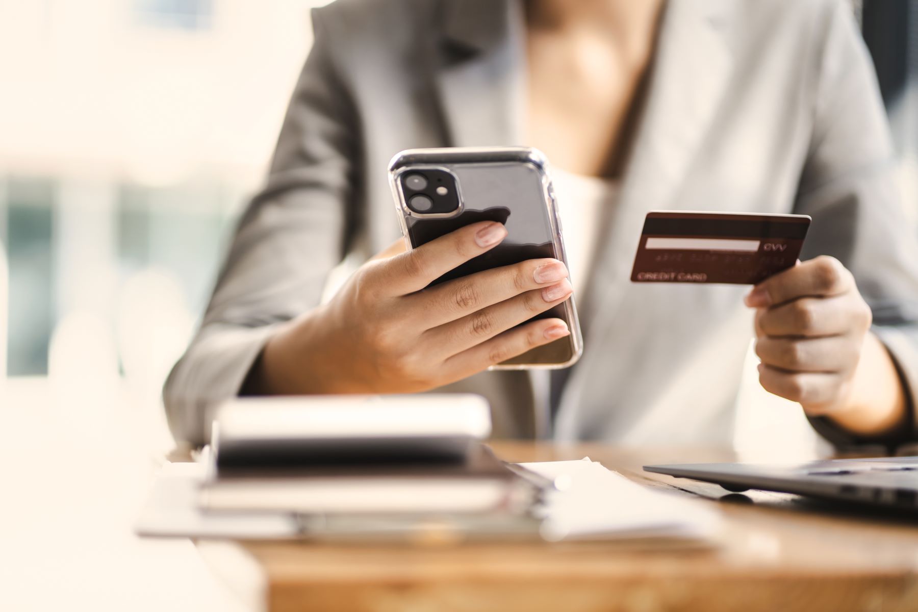 Person holding mobile phone and bank card