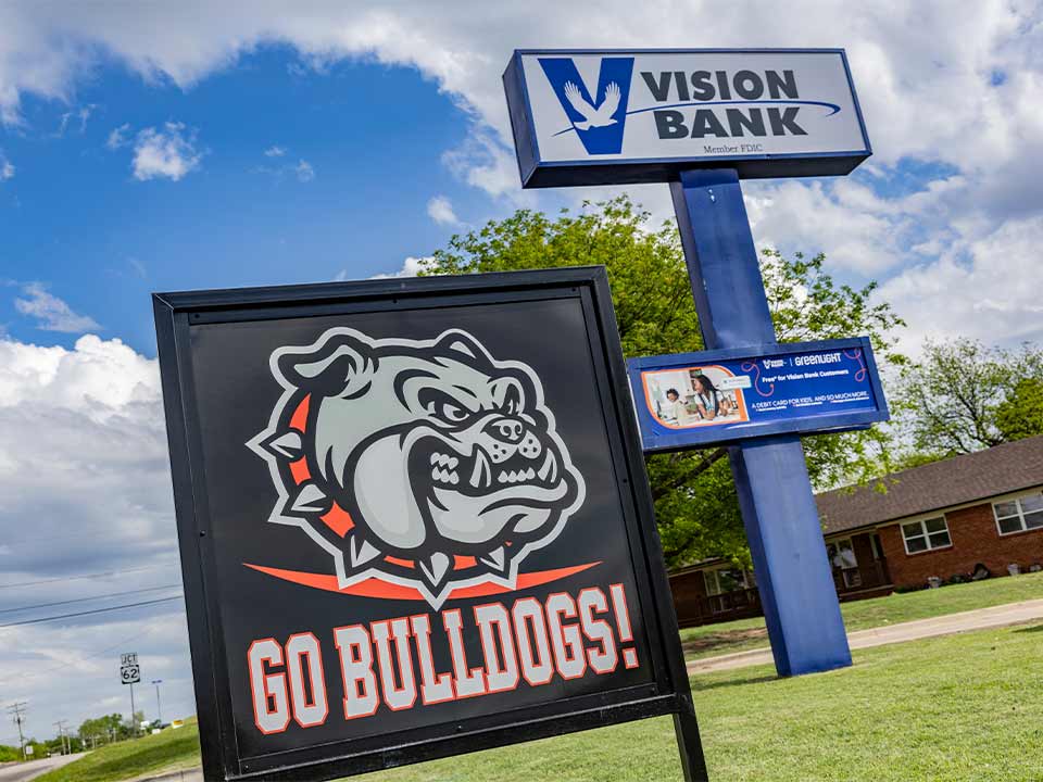 Vision Bank exterior sign with Go Bulldogs sign in yard