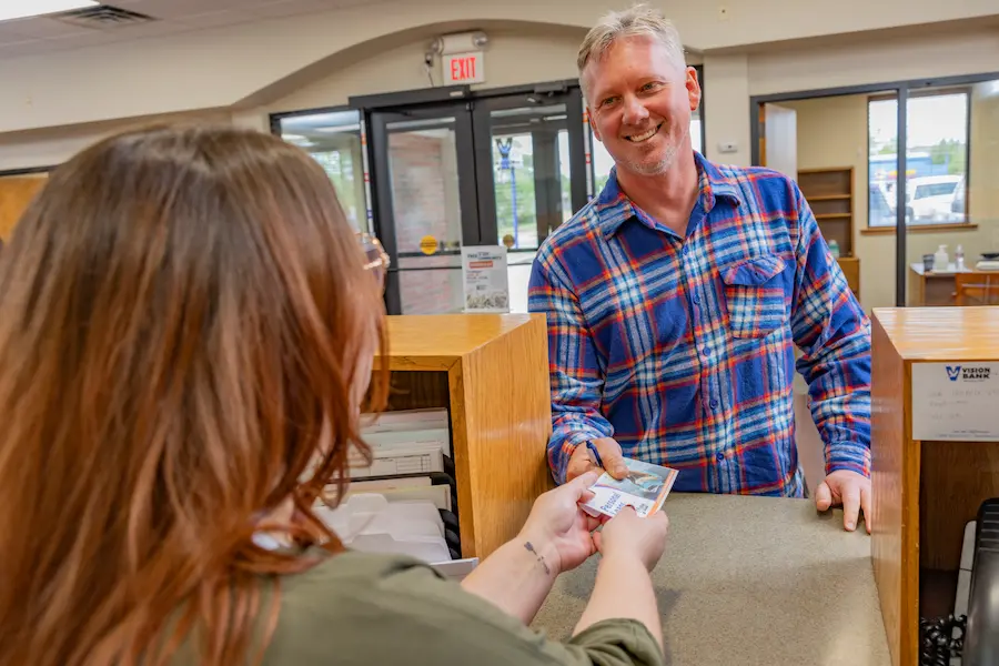 Vision Bank customer receiving money at the teller line.