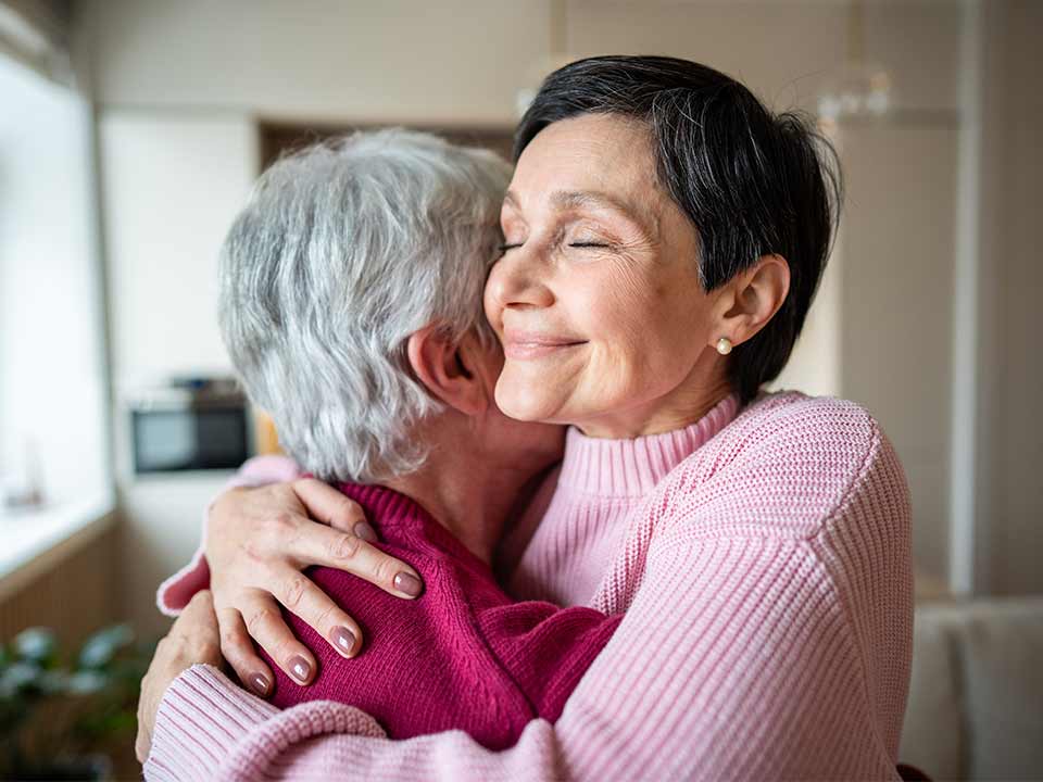 woman hugging elderly mother