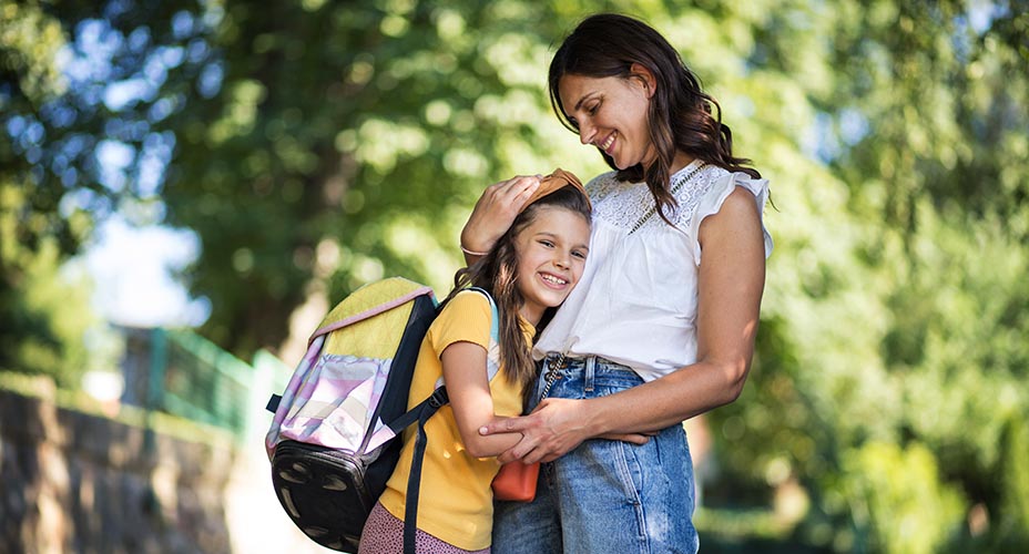 mom holding daughter heading off to school